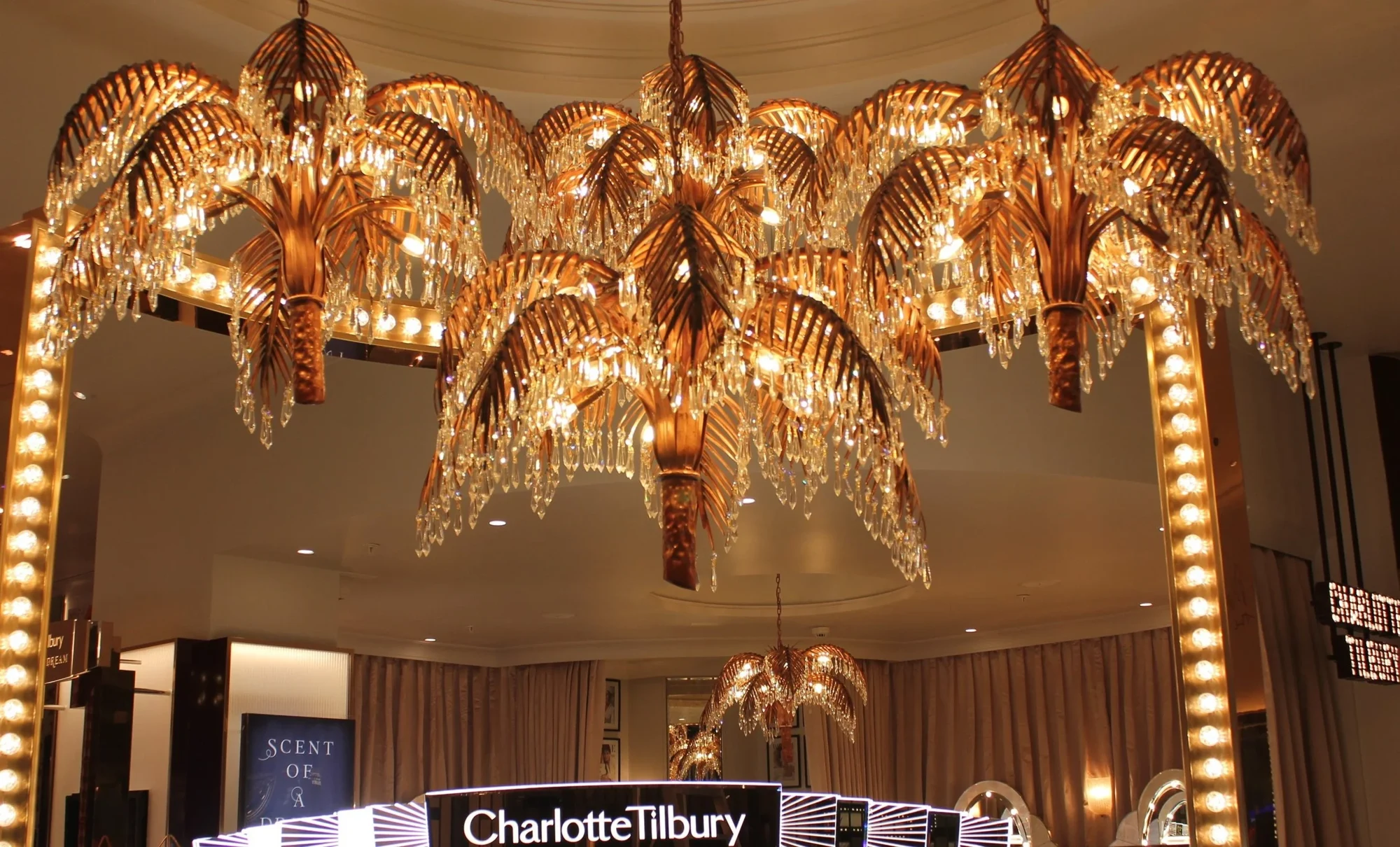 Handmade copper palm chandeliers in a Charlotte Tilbury store